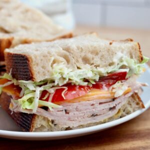 A sourdough turkey sandwich cut in half on a plate.