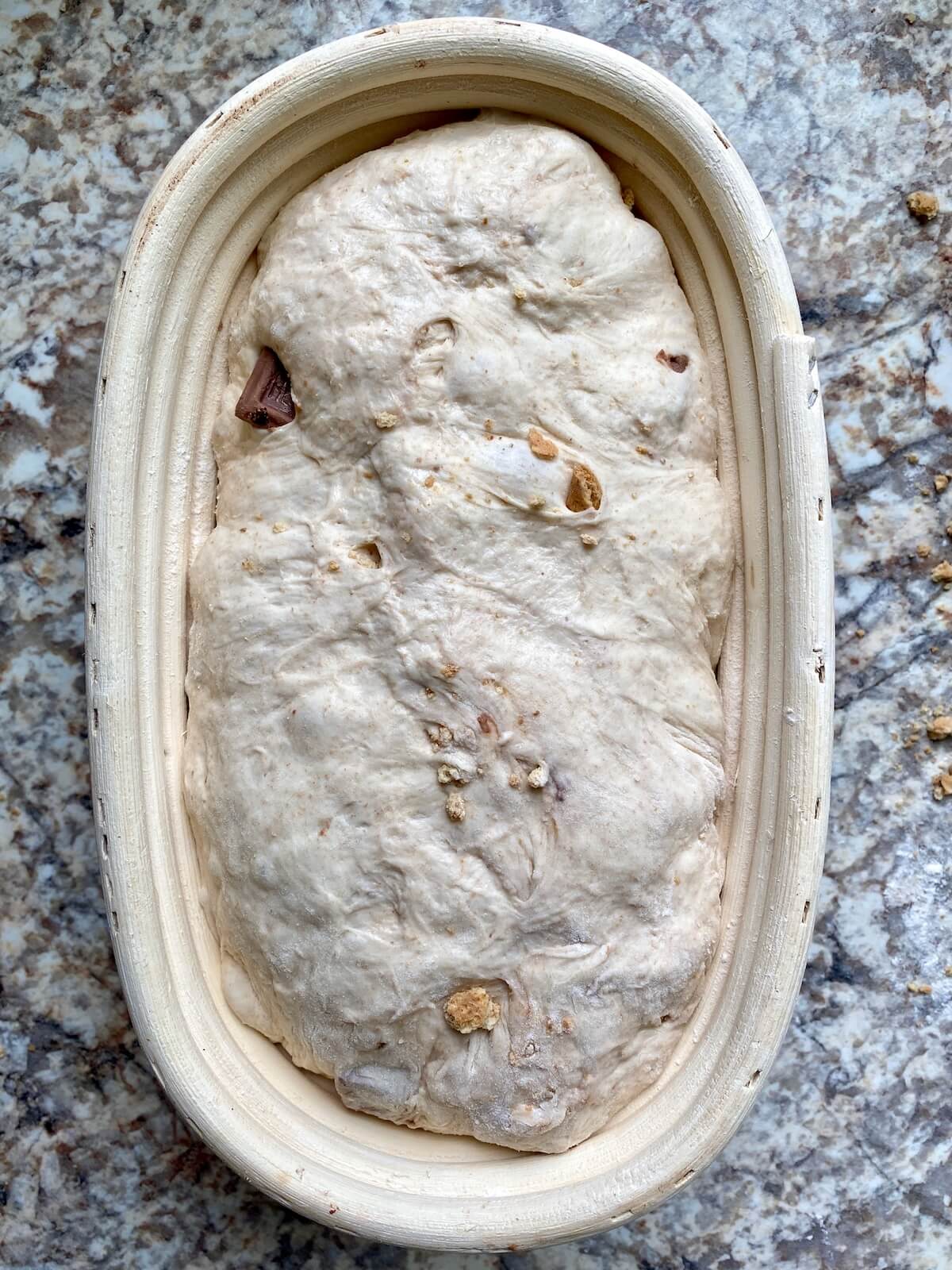 Sourdough s'mores bread in a batard-shaped proofing basket.