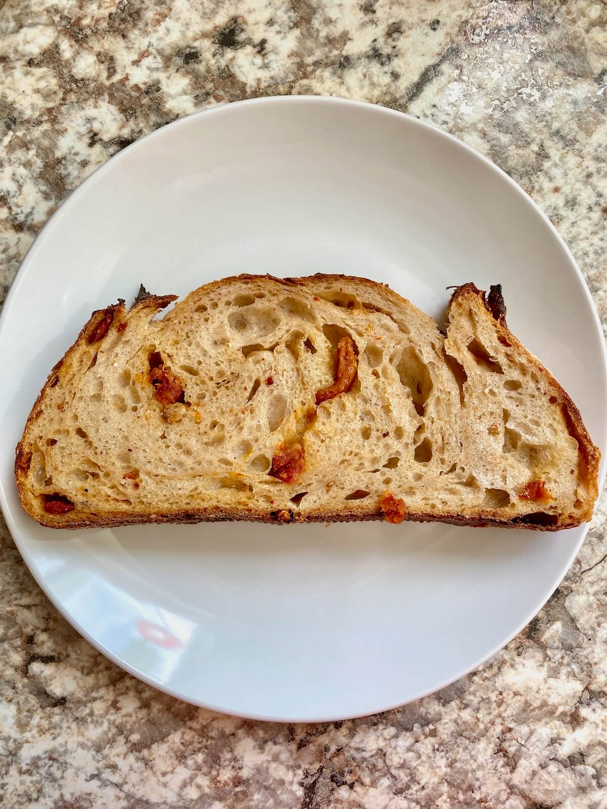 A piece of sourdough bread on a small plate.