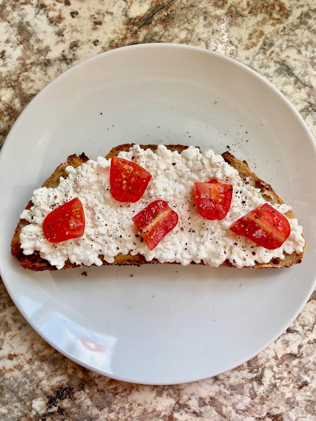 Sourdough toast topped with cottage cheese and tomatoes.