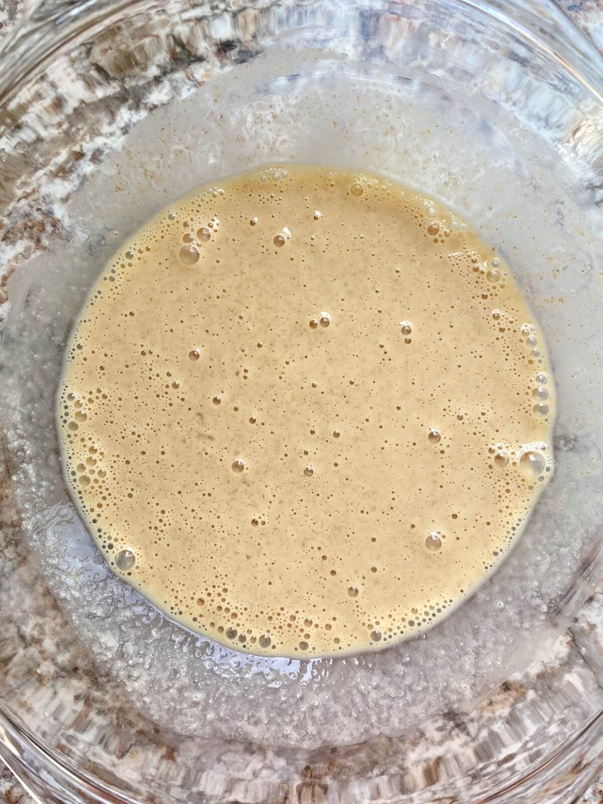 The wet ingredients, including sourdough discard, mixed together in a glass bowl.