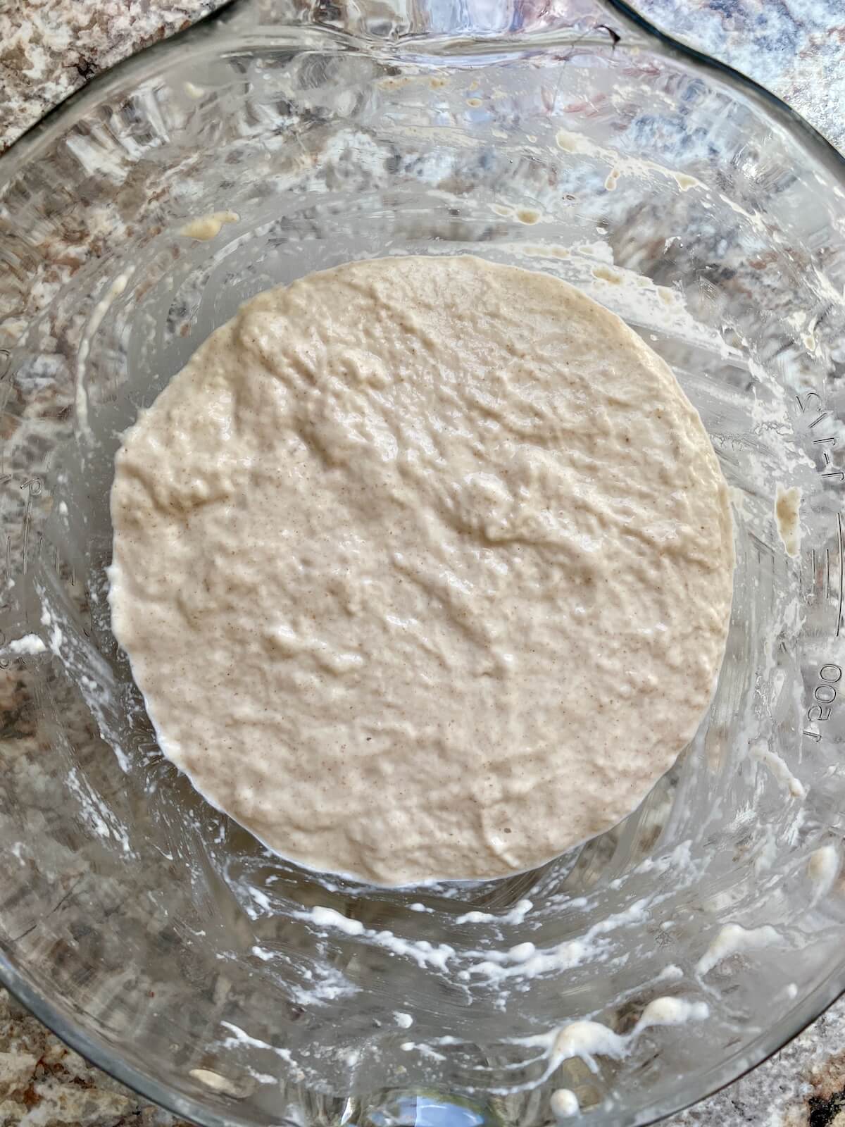 Sourdough focaccia dough mixed in a glass bowl.