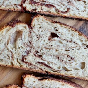 Slices of cinnamon sugar sourdough bread on a wooden cutting board.