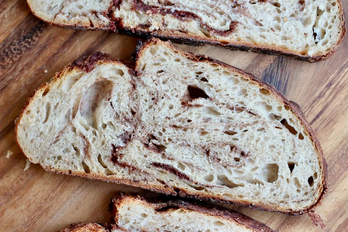 Slices of cinnamon sugar sourdough bread on a wooden cutting board.