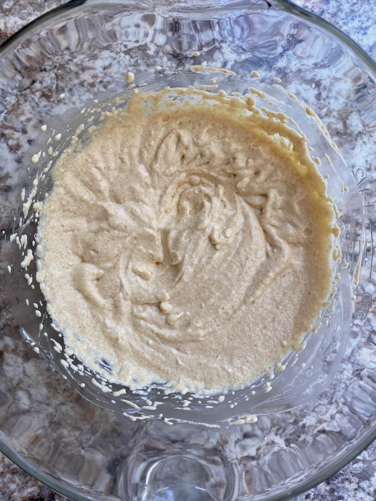 The wet ingredients for the cake mixed together in a glass bowl.