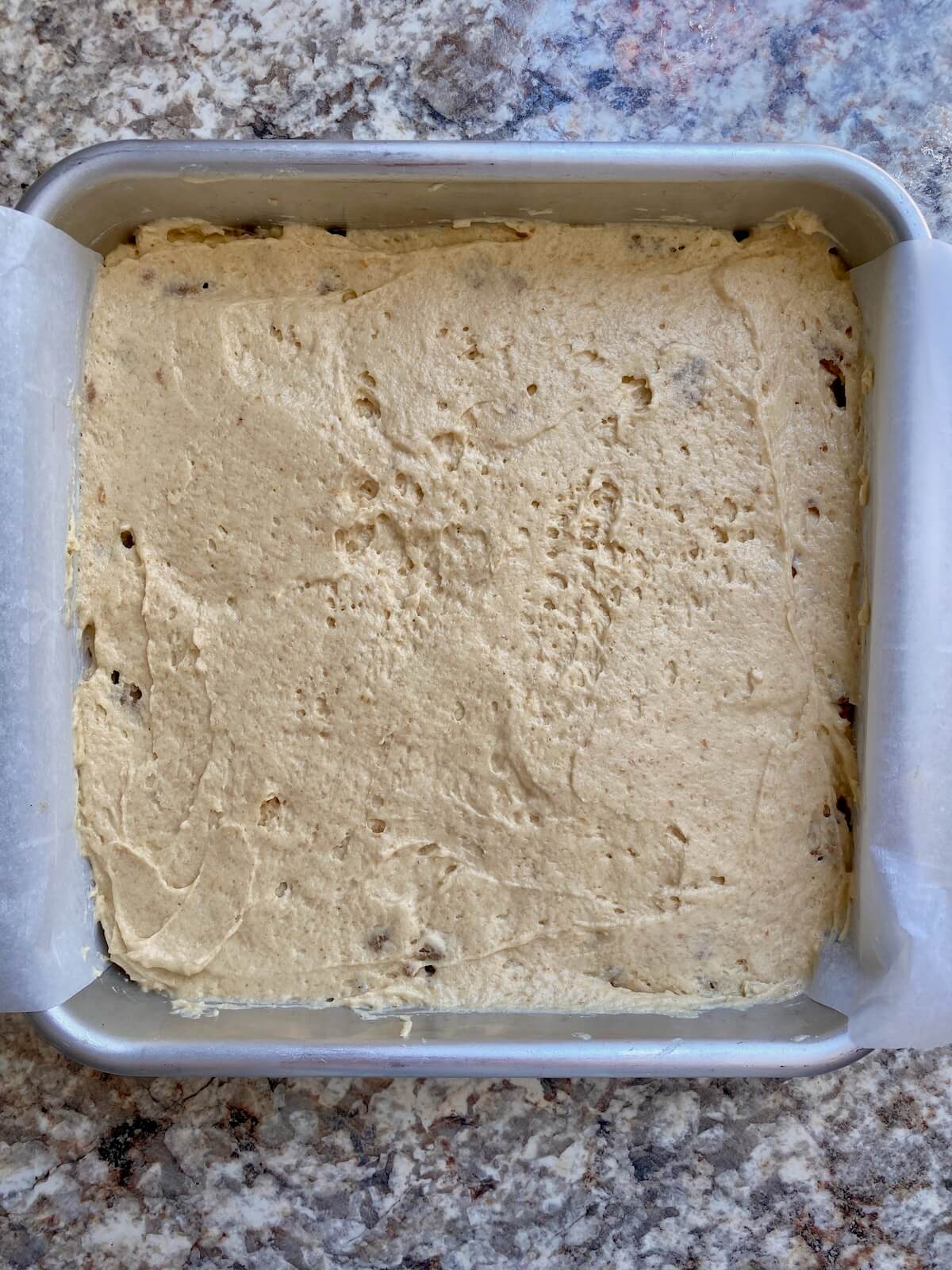 The rest of the cake batter spread on top of the crumble filling layer in a square cake pan.