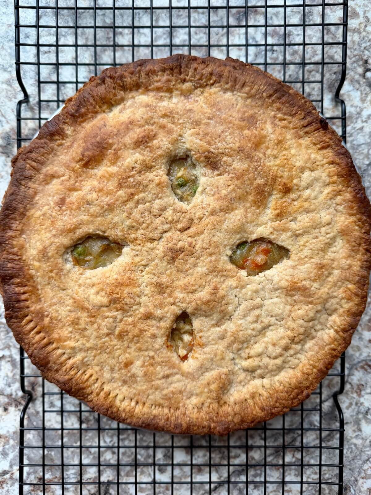 Baked sourdough chicken pot pie cooling on a wire cooling rack.