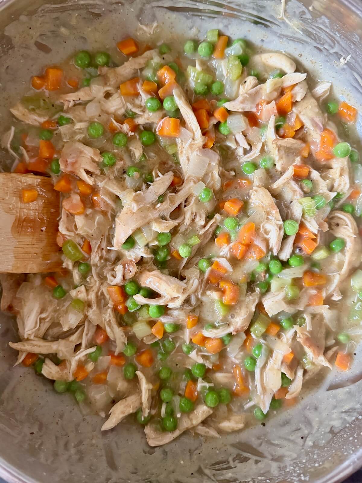 Chicken pot pie filling in a stainless steel pot.
