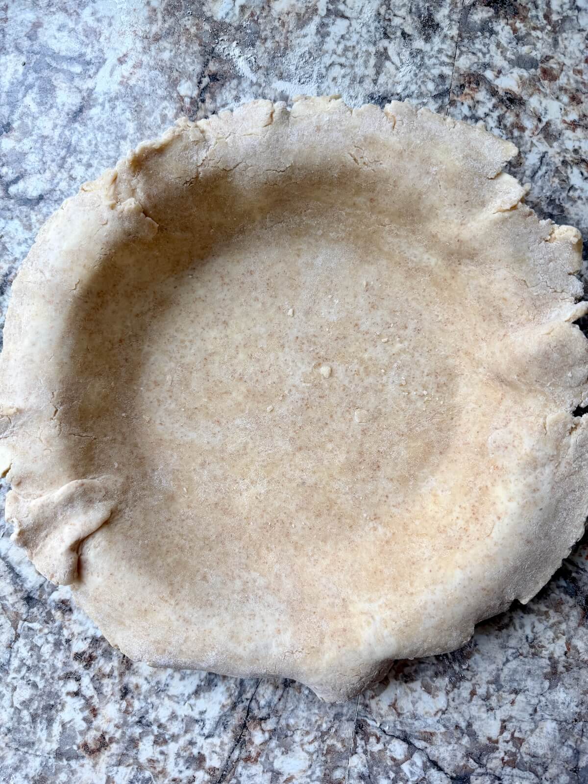 Sourdough discard pie crust rolled out and placed in the bottom of a pie plate.