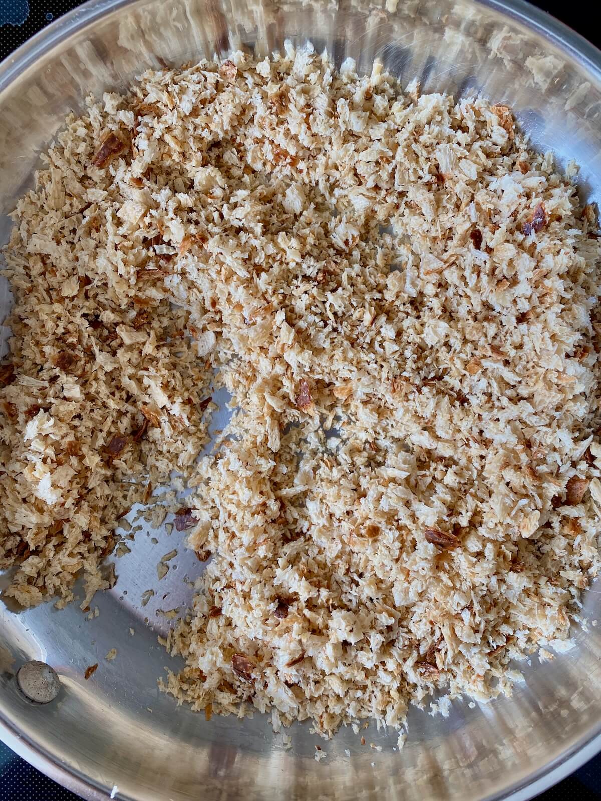 Sourdough bread breadcrumbs in a stainless steel skillet.