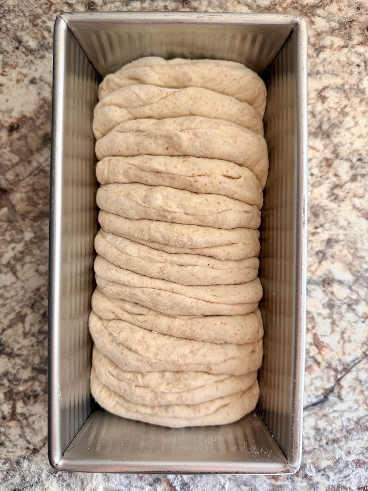 Sourdough pull apart garlic bread in a loaf pan before proofing.
