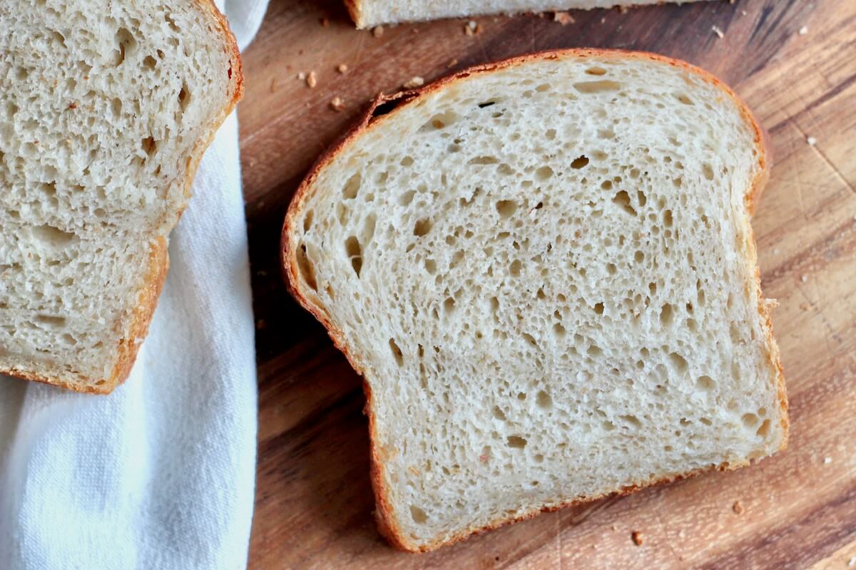 A slice of sourdough potato bread on a cutting board.