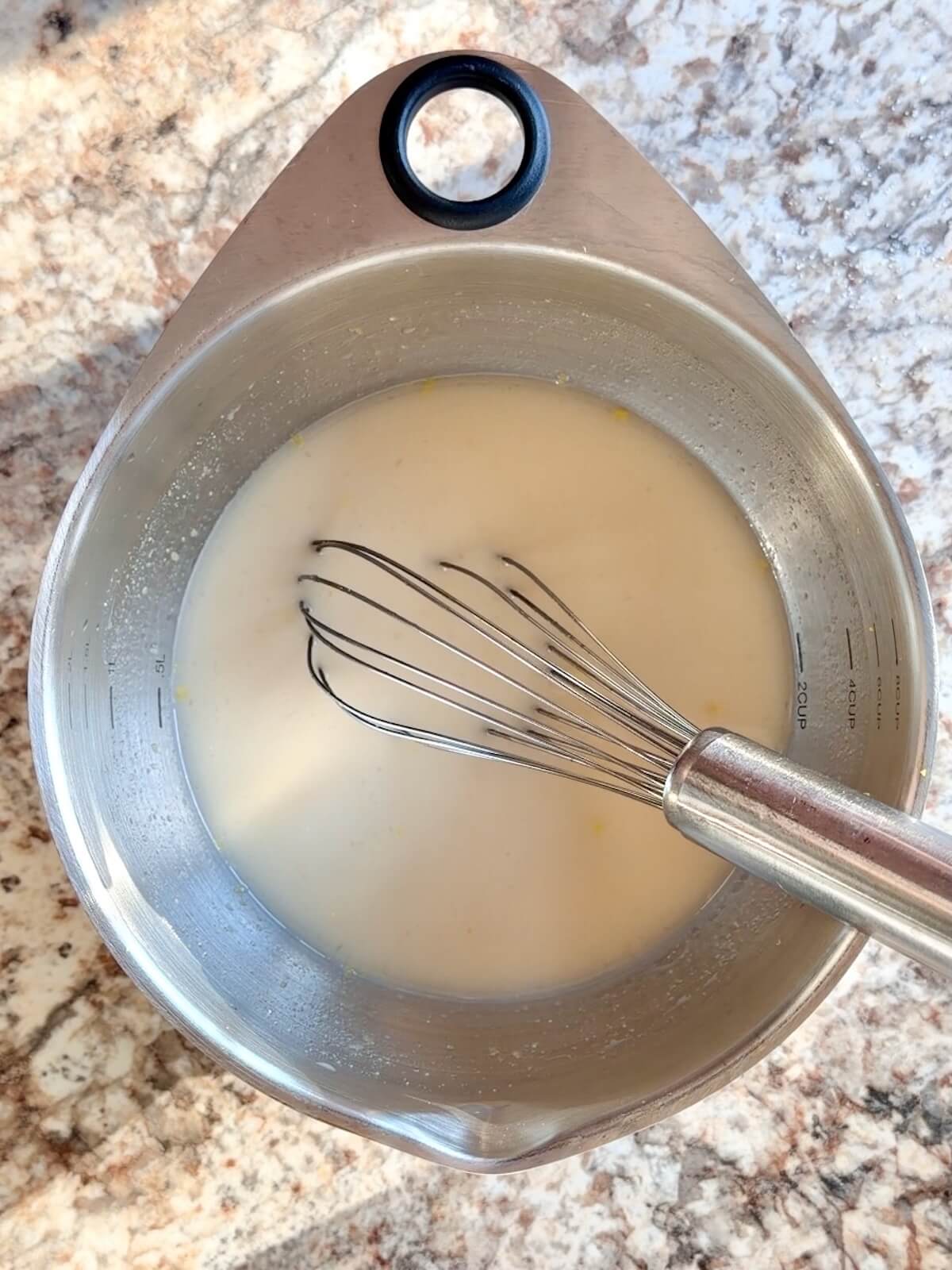 Sourdough starter, water, lemon juice, and lemon zest whisked together in a mixing bowl.