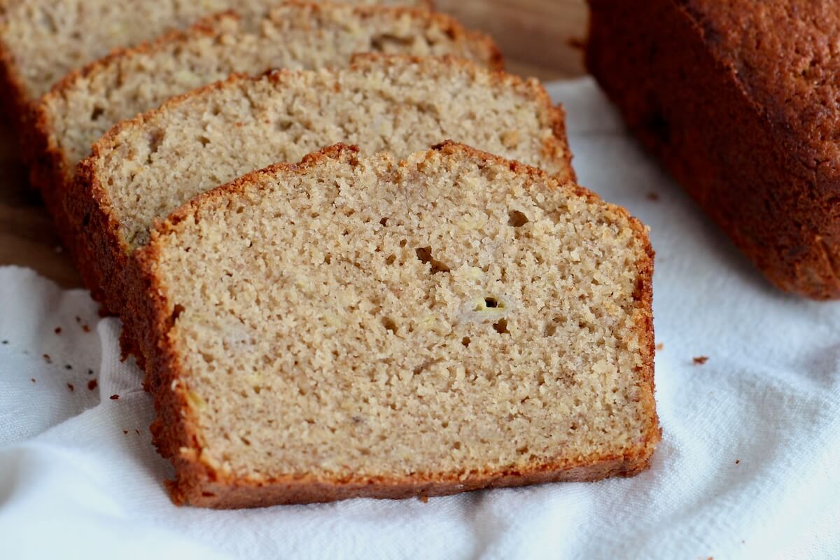 Slices of sourdough discard banana bread on a white cloth napkin.