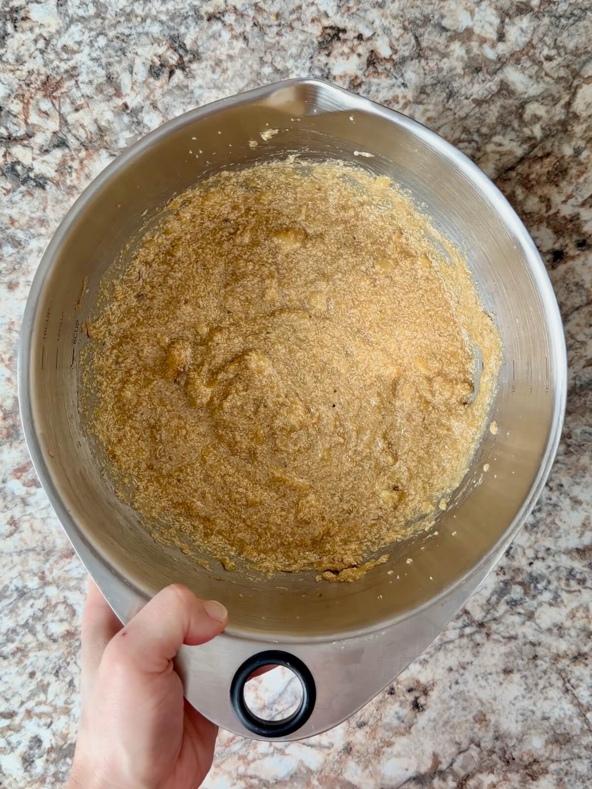 Bananas, sourdough discard, and other wet ingredients mixed together in a bowl.