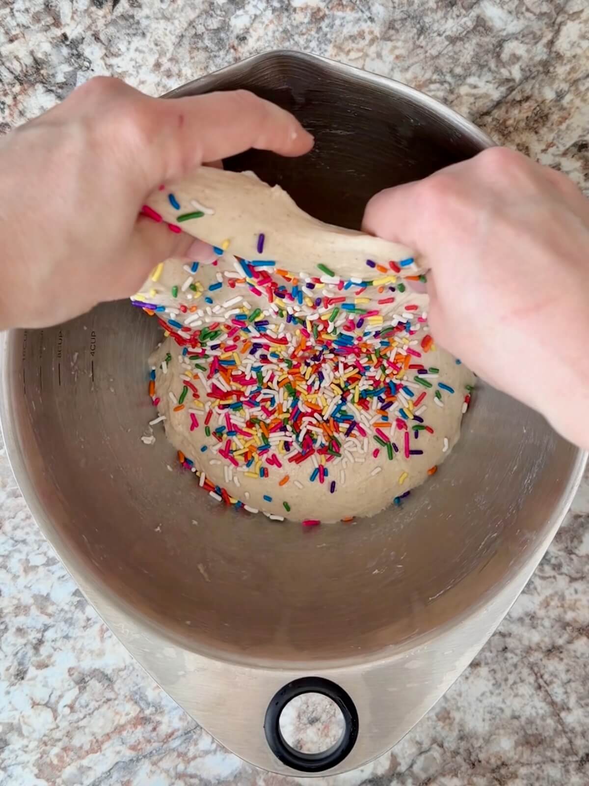 Sprinkles being folded into sourdough bread dough.