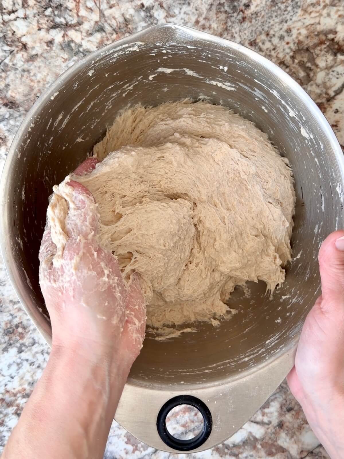 Sourdough bread dough mixed together in a stainless steel bowl.
