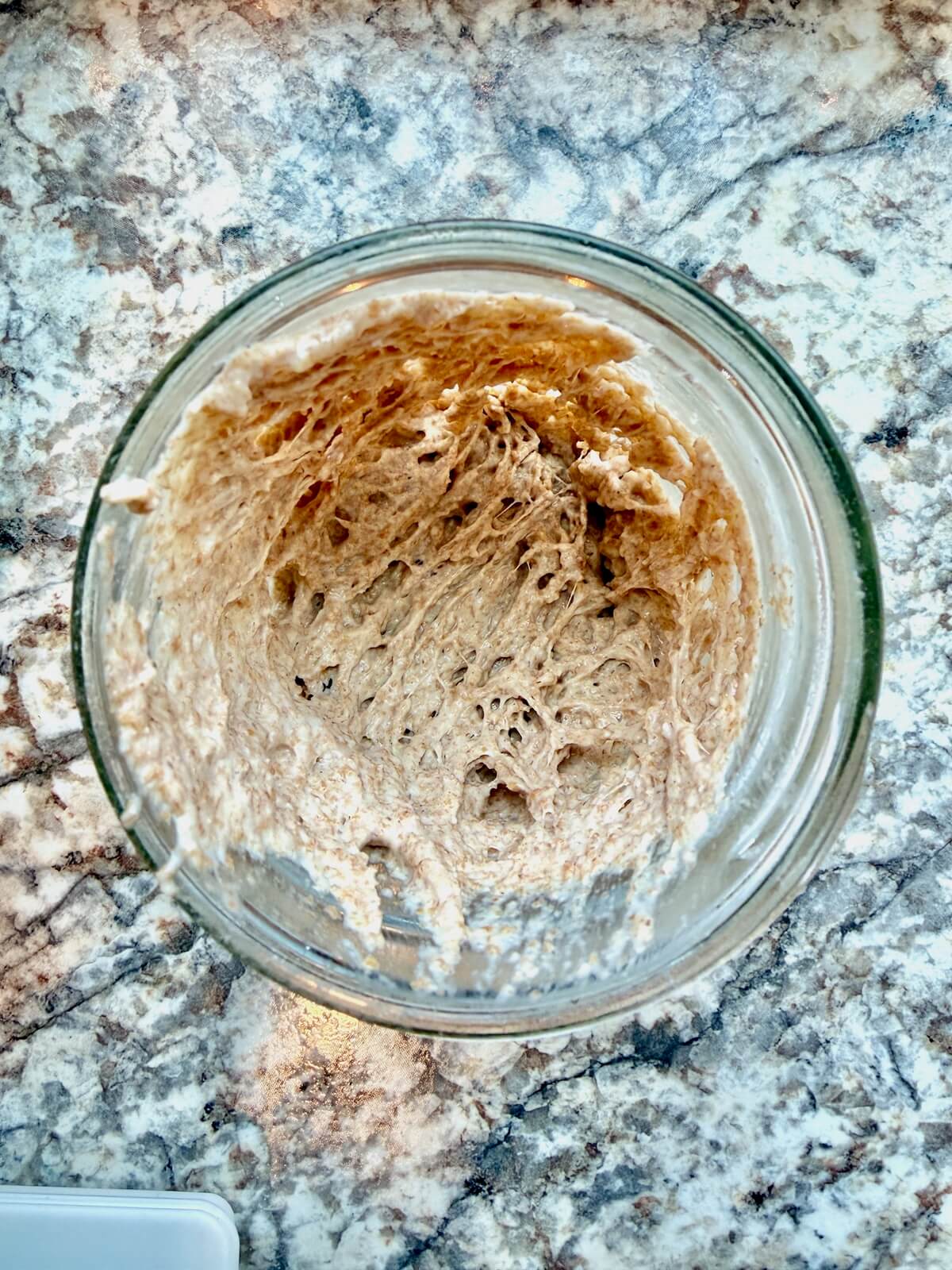 An active sourdough starter in a glass mason jar.