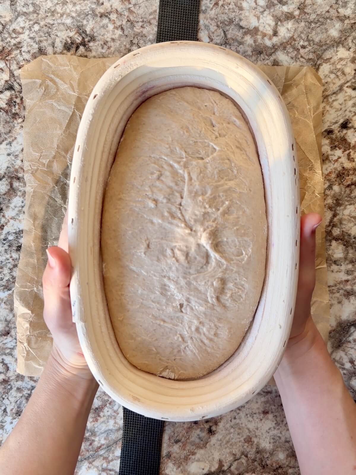 Beer sourdough bread dough in an oval proofing basket after cold proofing overnight.