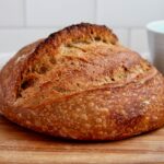 A whole loaf of coffee sourdough bread on a cutting board.