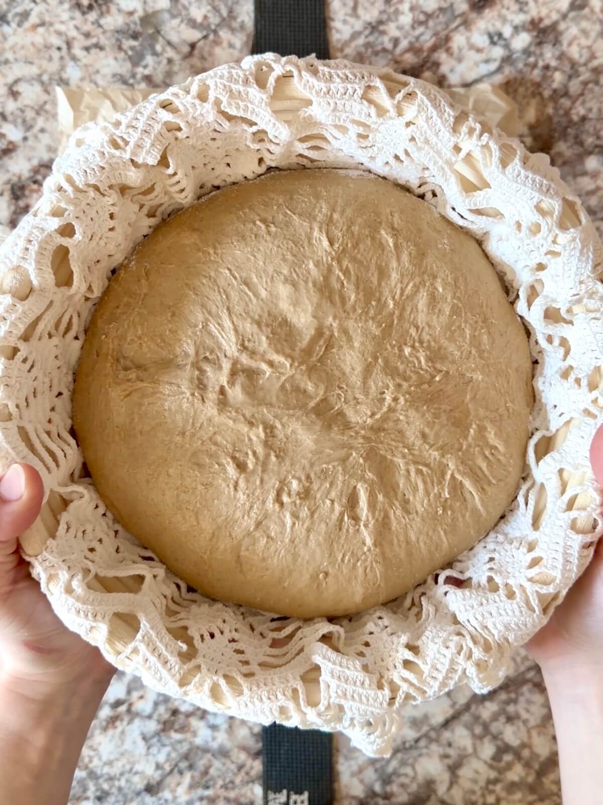 The shaped dough in a round, lined proofing basket before cold proofing overnight.