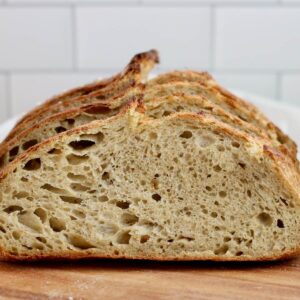 Slices of pesto sourdough bread on a wooden cutting board.