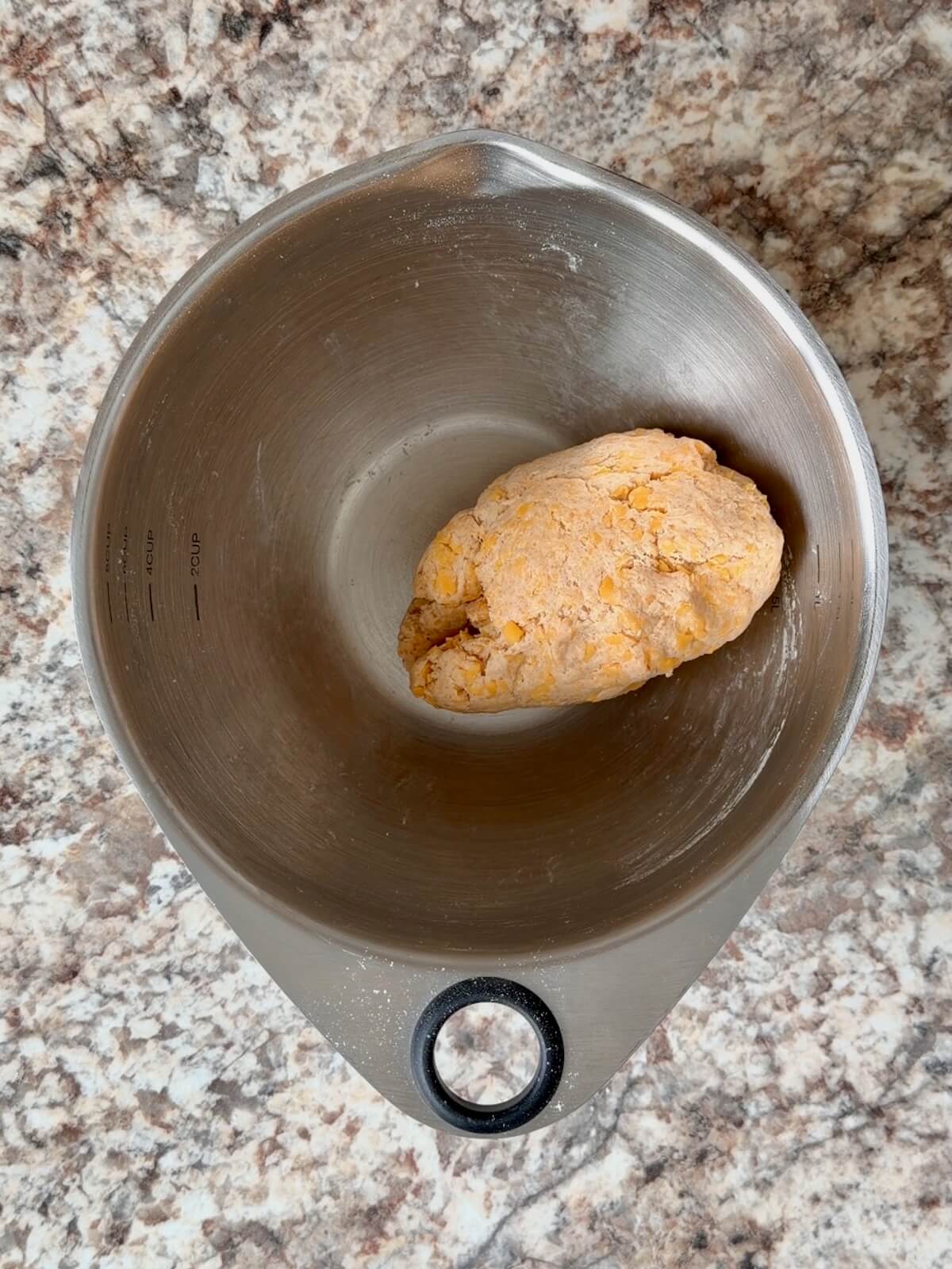 Cheddar cheese sourdough cracker dough in a mixing bowl.