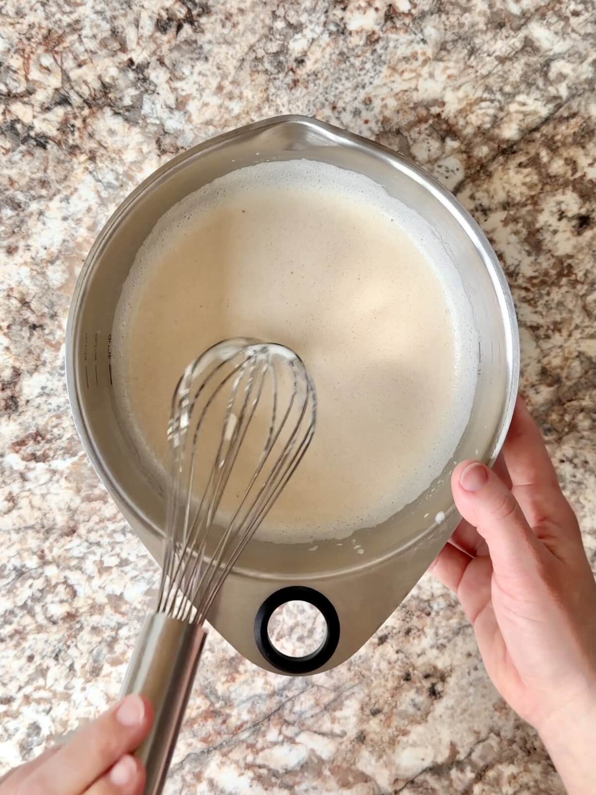 Whey protein powder, water, and sourdough starter whisked together in a bowl.