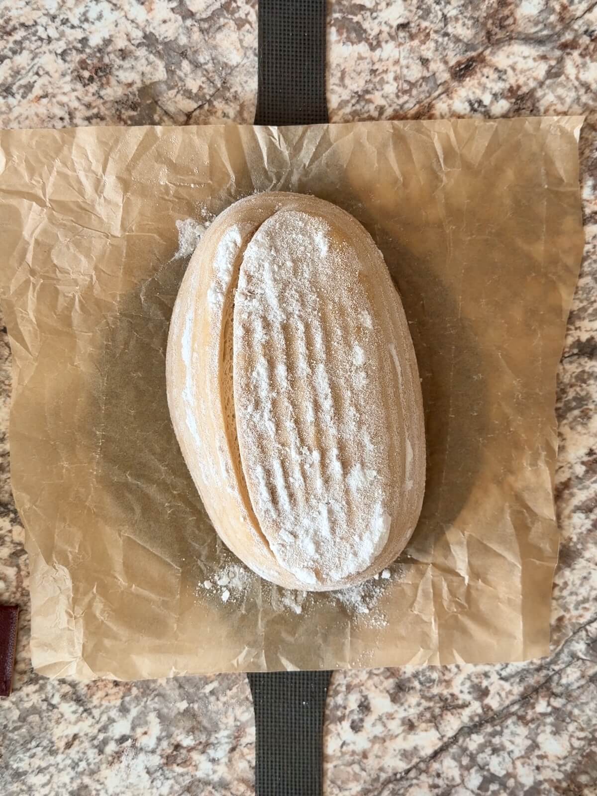 Scored dough on a bread sling.