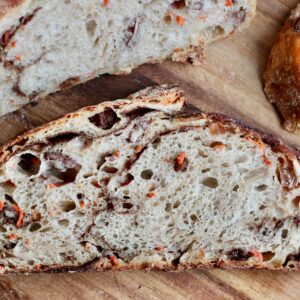 Slices of carrot cake sourdough bread on a wooden cutting board.