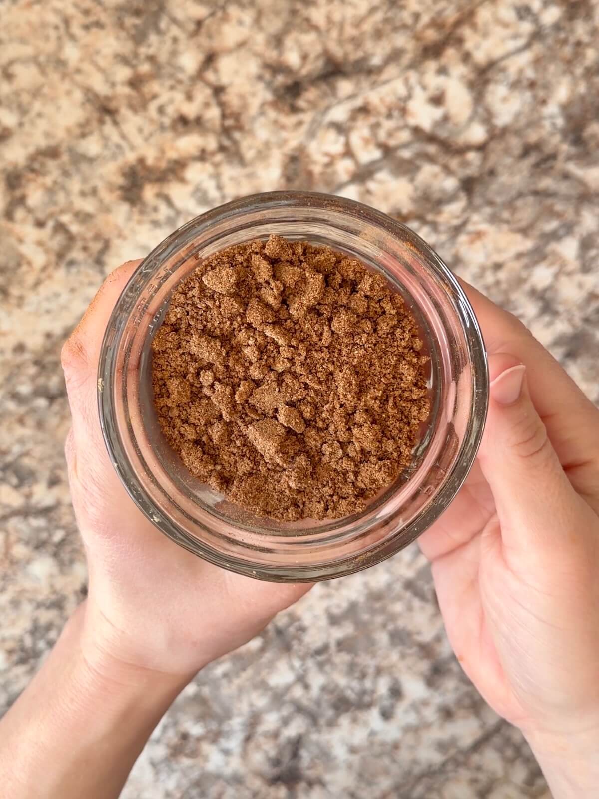 A mixture of brown sugar, cinnamon, and other spices in a small glass bowl.