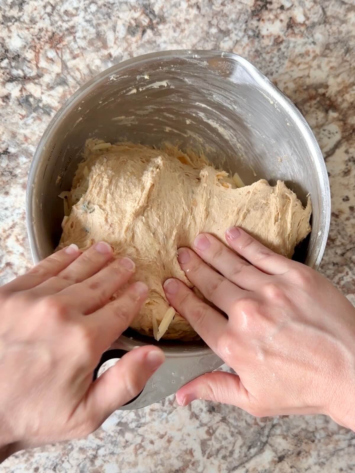 Gruyere cheese being folded into the dough.