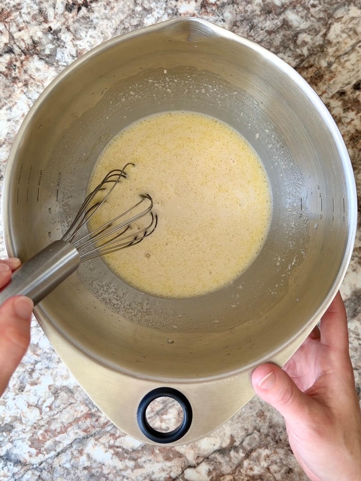 Water, active sourdough starter, and olive oil whisked together in a bowl.