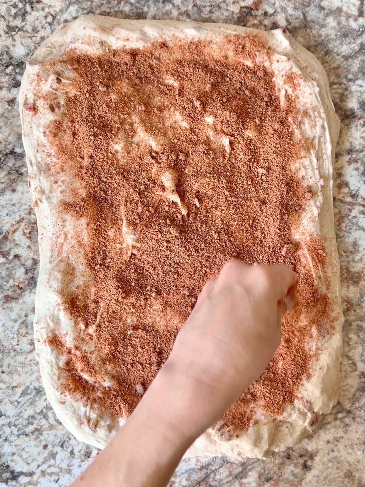 Brown sugar and chipotle powder being sprinkled over the fermented dough.
