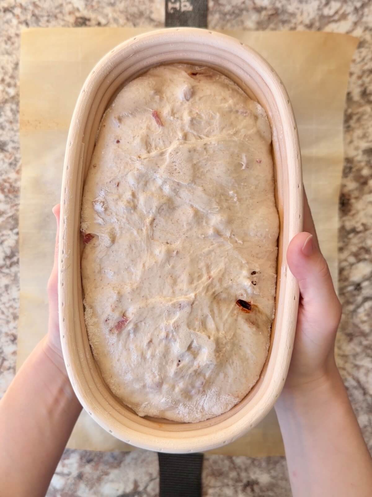 The shaped dough in an oval proofing basket after cold proofing overnight.