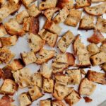 Sourdough croutons on an aluminum baking sheet.