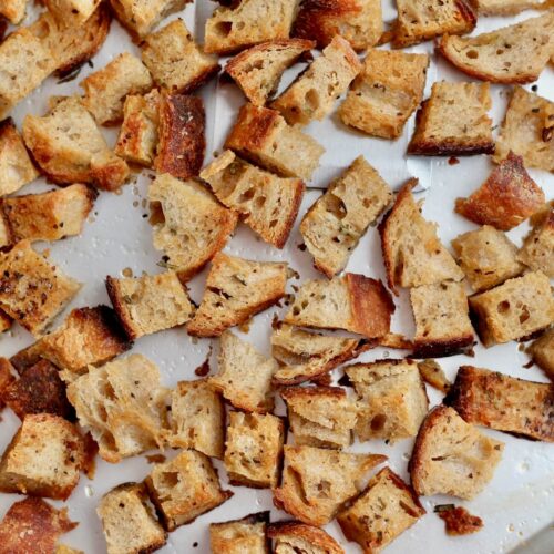 Sourdough croutons on an aluminum baking sheet.