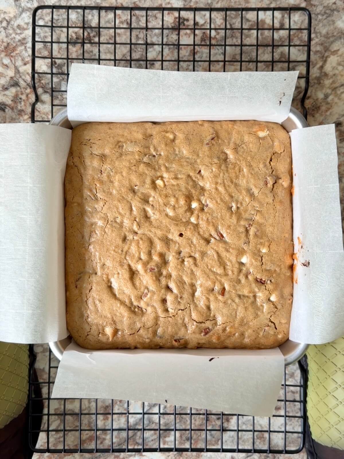 Baked sourdough maple pecan bars in a baking pan on a wire cooling rack.