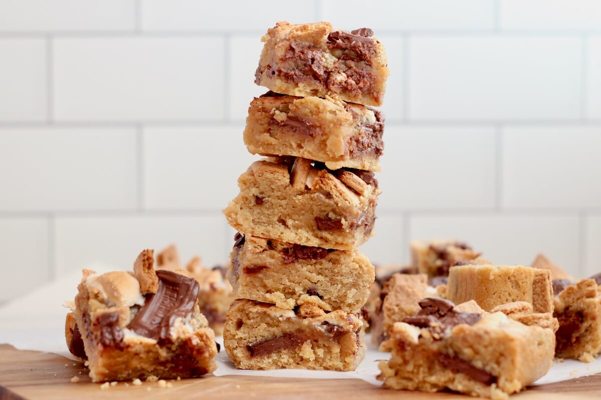 A stack of 5 sourdough s'mores bars surrounded by more bars on the table next to the stack.