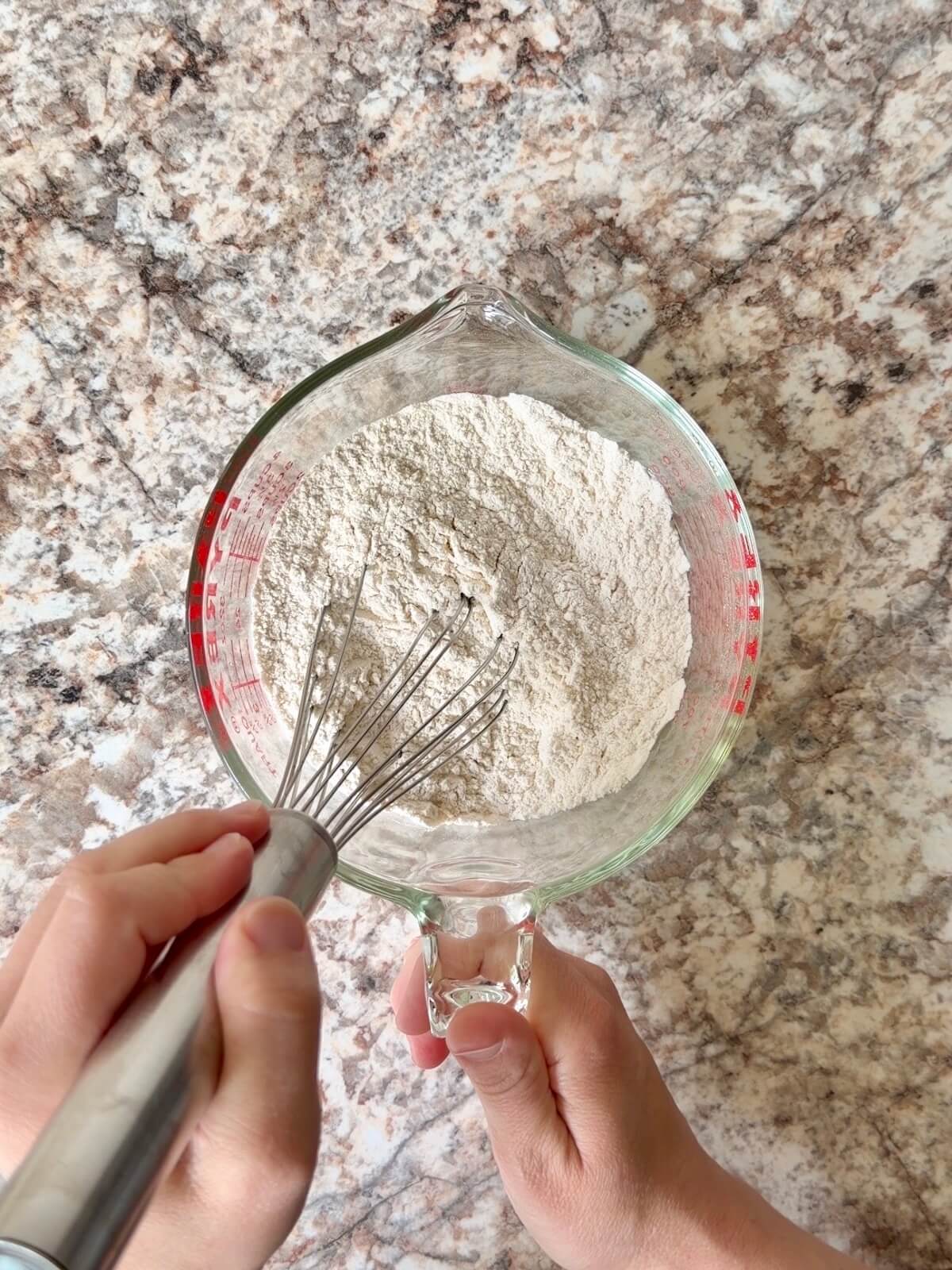 Flour, salt, and baking powder whisked together in a bowl.
