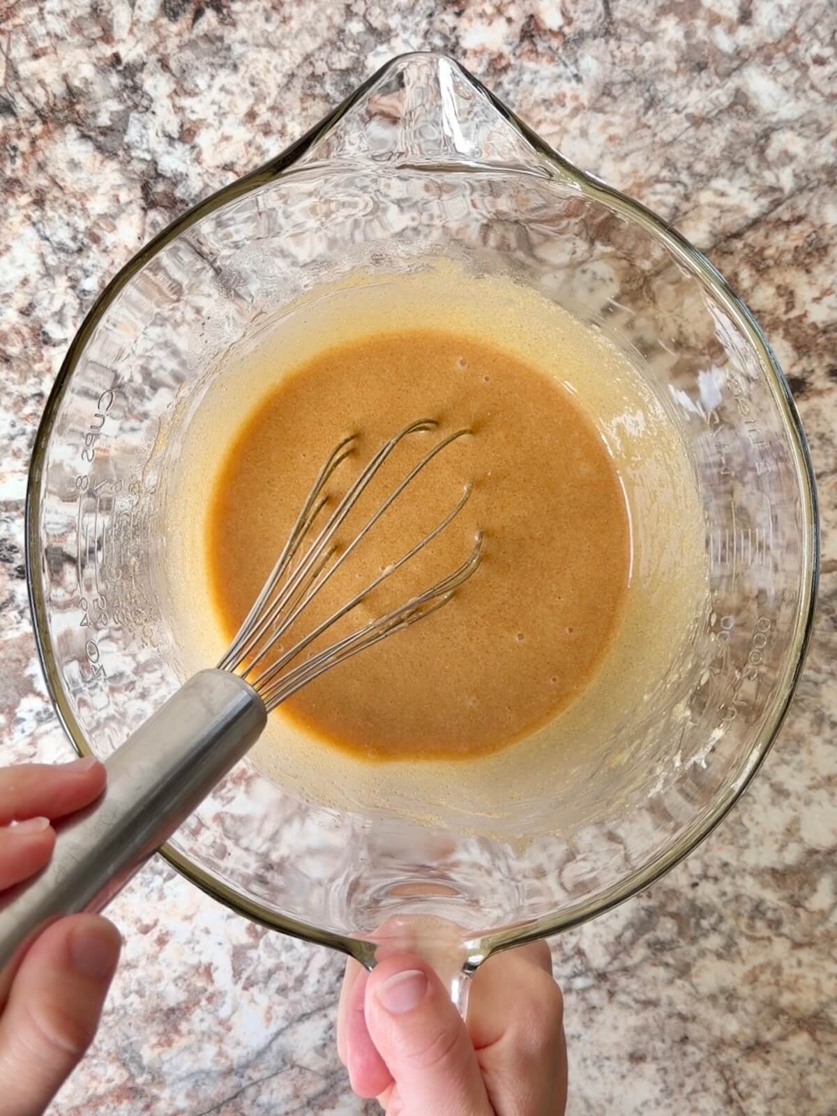 Butter, sourdough discard, and other wet ingredients whisked together in a bowl.