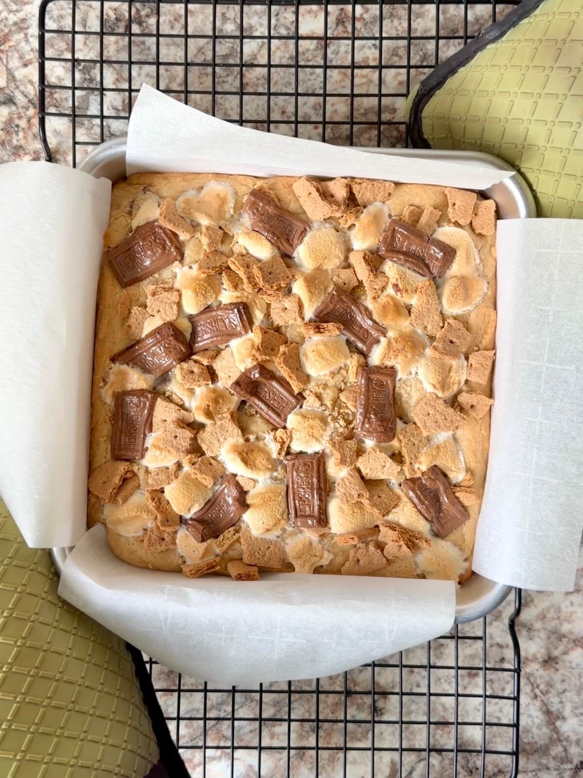 Baked s'mores sourdough blondies in a pan on a wire cooling rack.