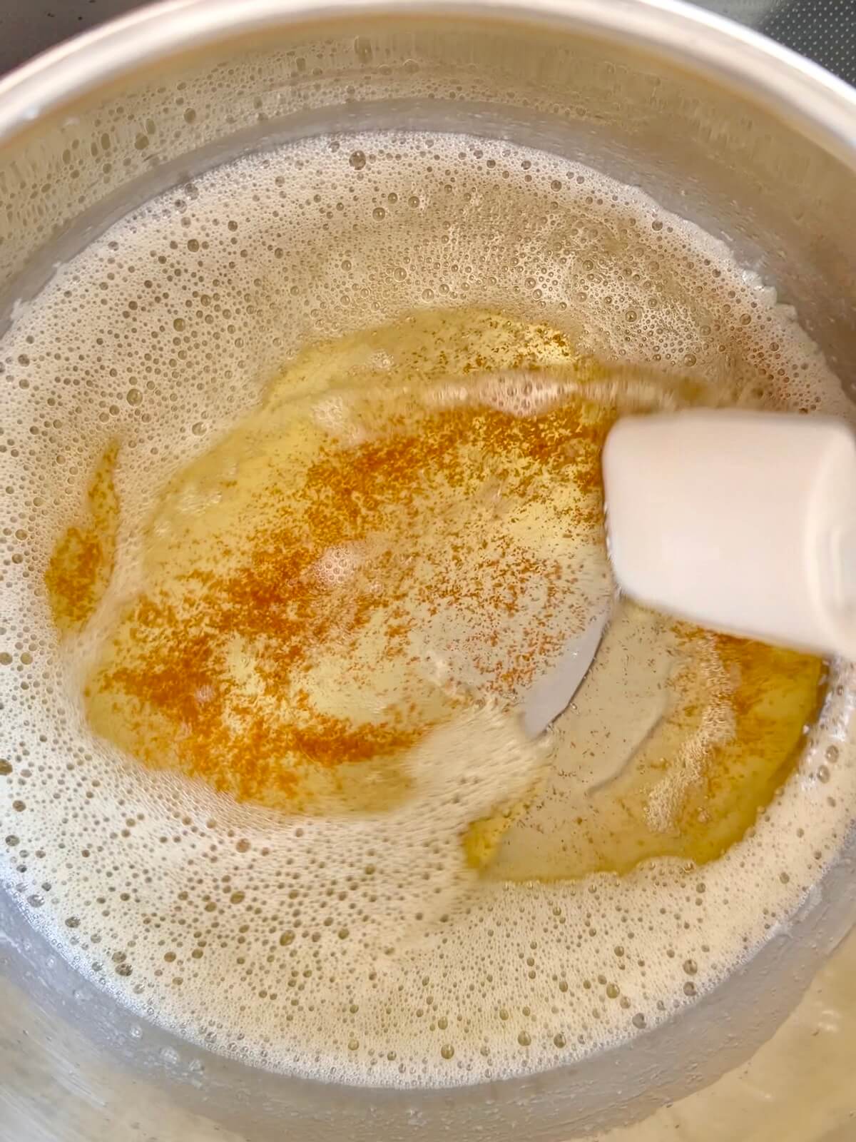 A stainless steel pot with brown butter.