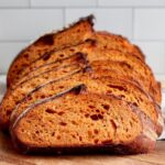 A sliced loaf of tomato basil sourdough bread.