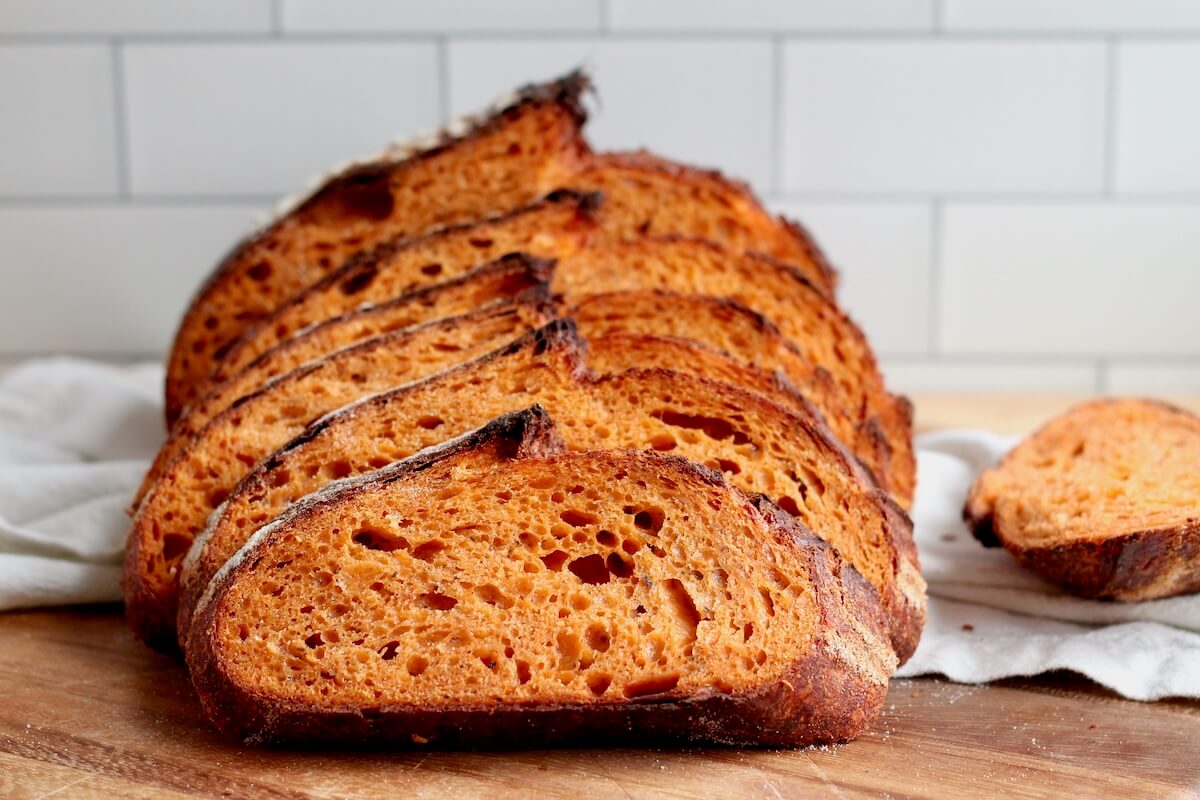 A sliced loaf of tomato basil sourdough bread.
