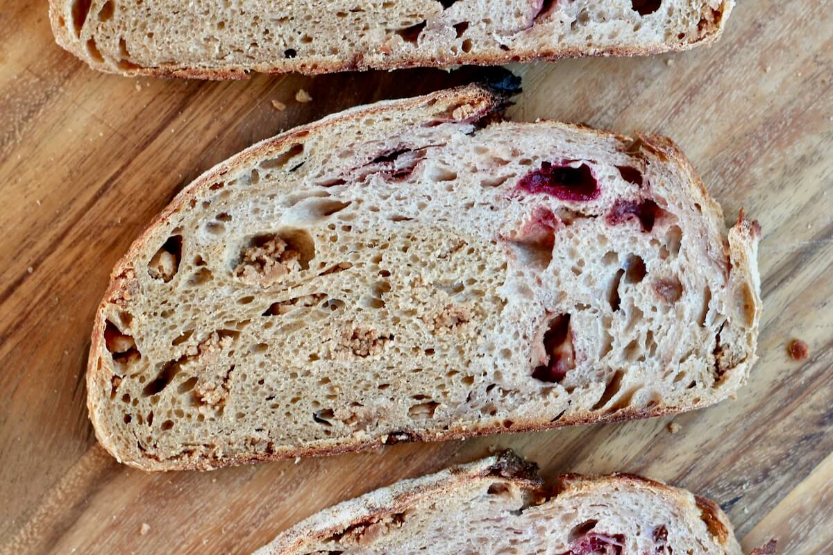 A slice of PB&J sourdough bread on a wooden cutting board.