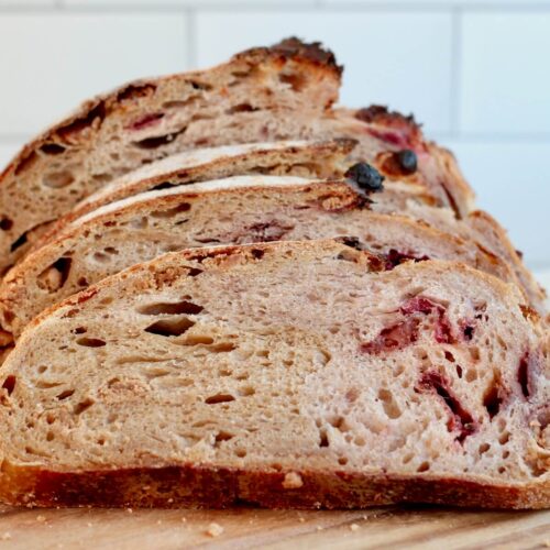 A sliced loaf of peanut butter and jelly sourdough bread on a cutting board.