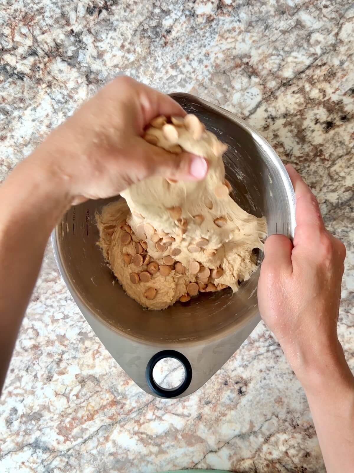 Peanut butter chips being folded into the peanut butter dough.