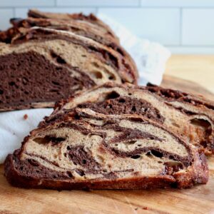 A sliced loaf of chocolate peanut butter sourdough bread on a cutting board.