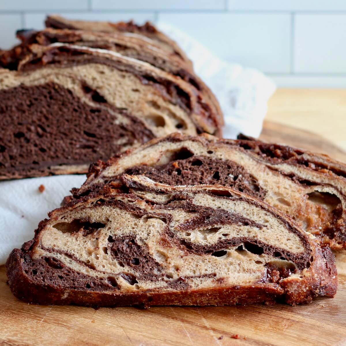 A sliced loaf of chocolate peanut butter sourdough bread on a cutting board.